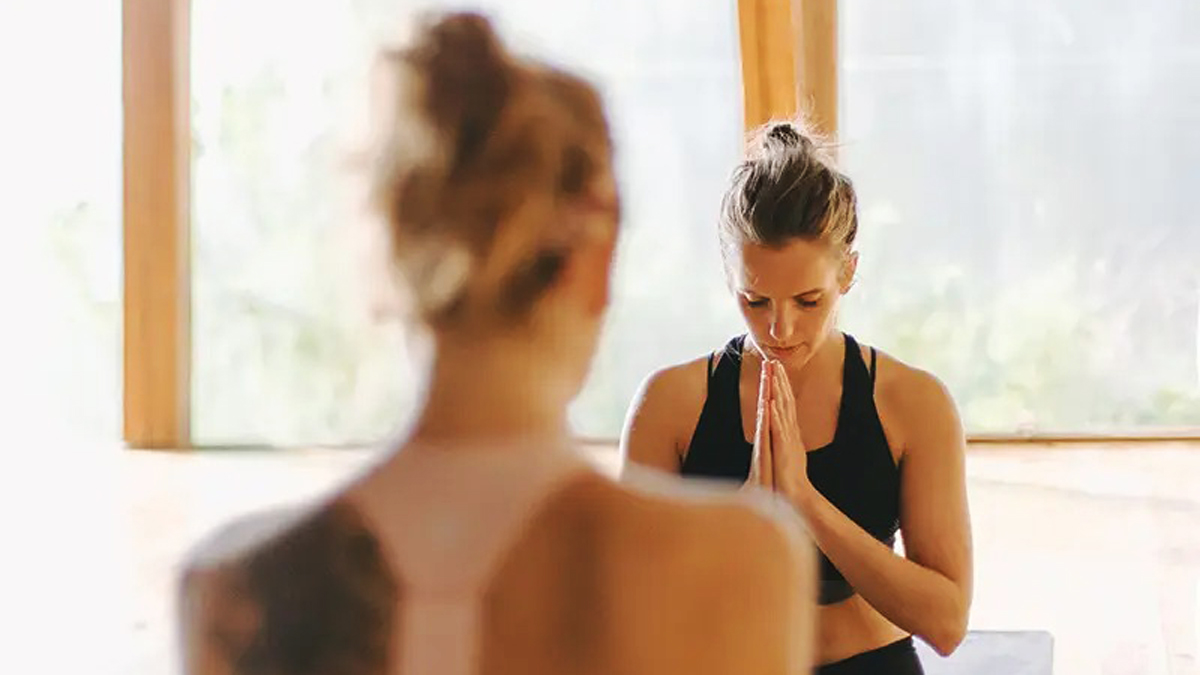 Jógaóra elején meditáló gyakorló összetett kézzel, nyugodt hangulatban