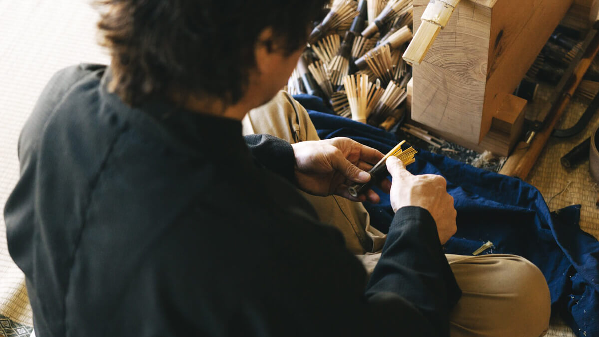 A chasen szálainak igazítása Chasen-készítő mester a műhelyben, a bambusz szálakat igazítja