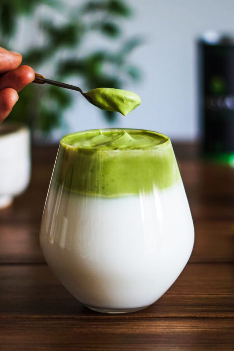 Kanalon megemelt sűrű zöld matcha hab a dalgona matcha tetejéről, közelről