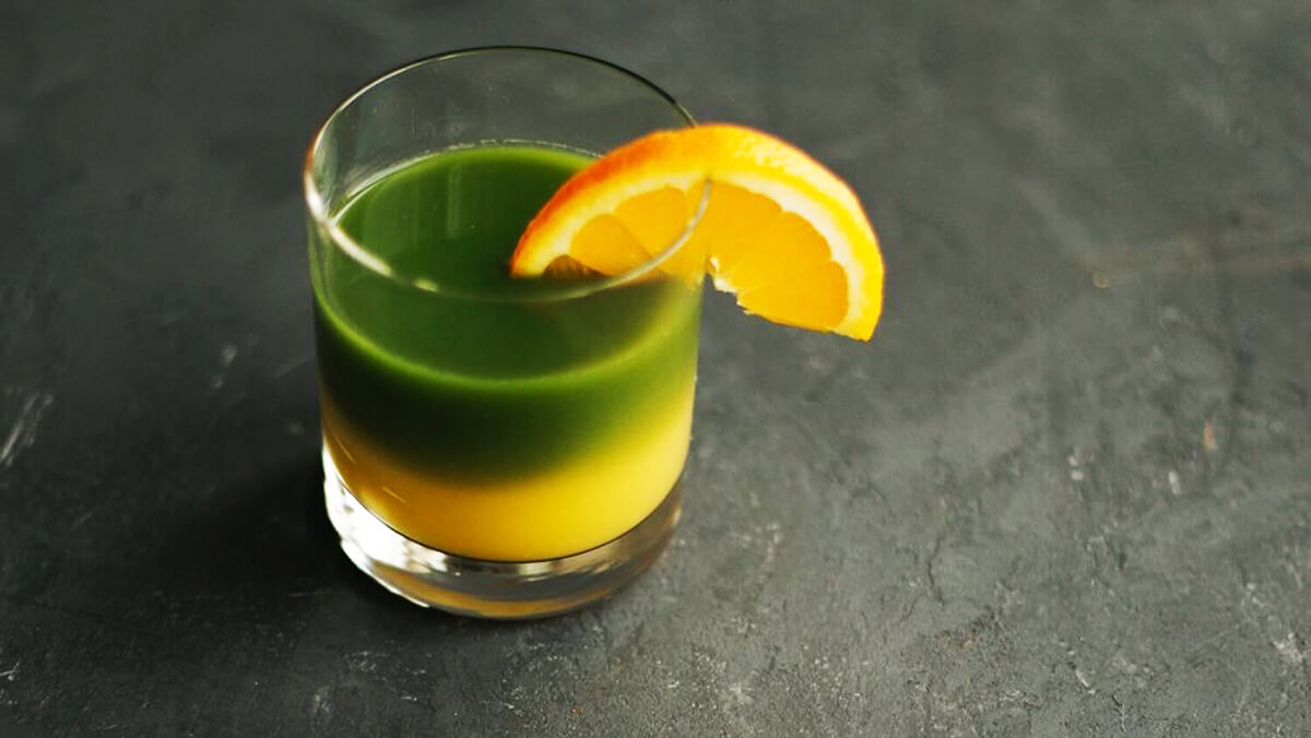 Kétrétegű matcha narancslével pohárban, narancsszelettel a peremen