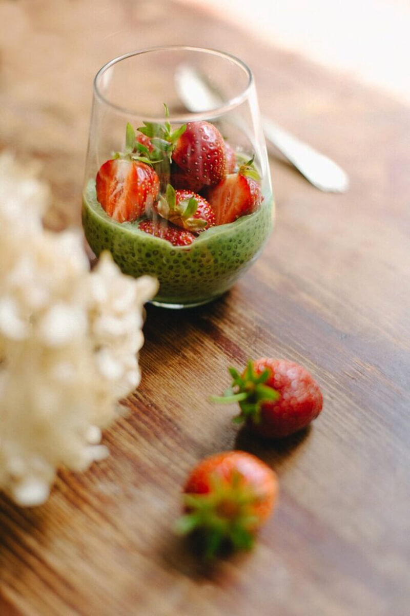 Kanálon krémes matchás chia puding textúra, háttérben eper