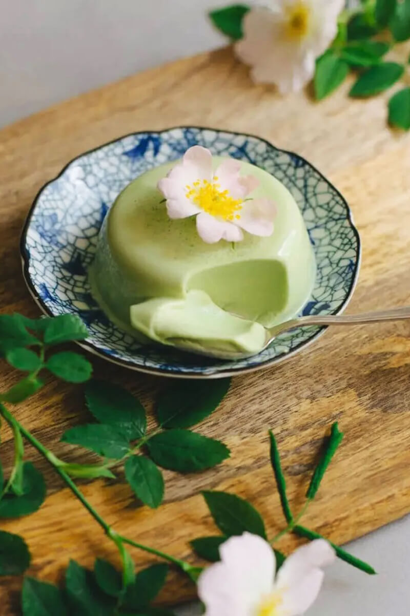Matcha panna cotta krémes állaga kanállal kiemelve, közelről