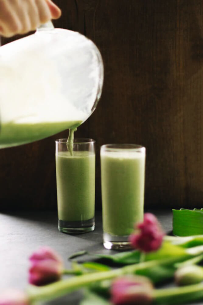 Krémes matcha ital öntése két magas pohárba, frappé tálalás