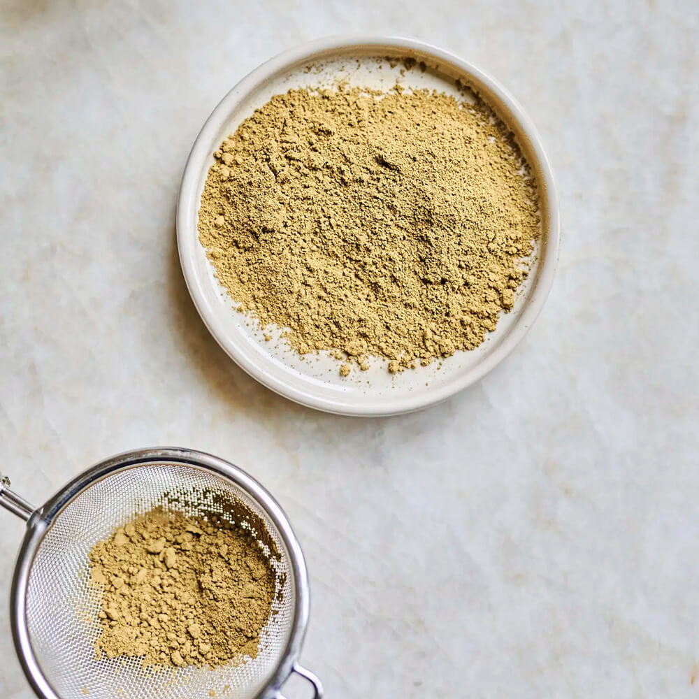 Moya Organikus Hojicha Por tálban és szűrőben, márvány felületen felülnézetben, előkészítéshez