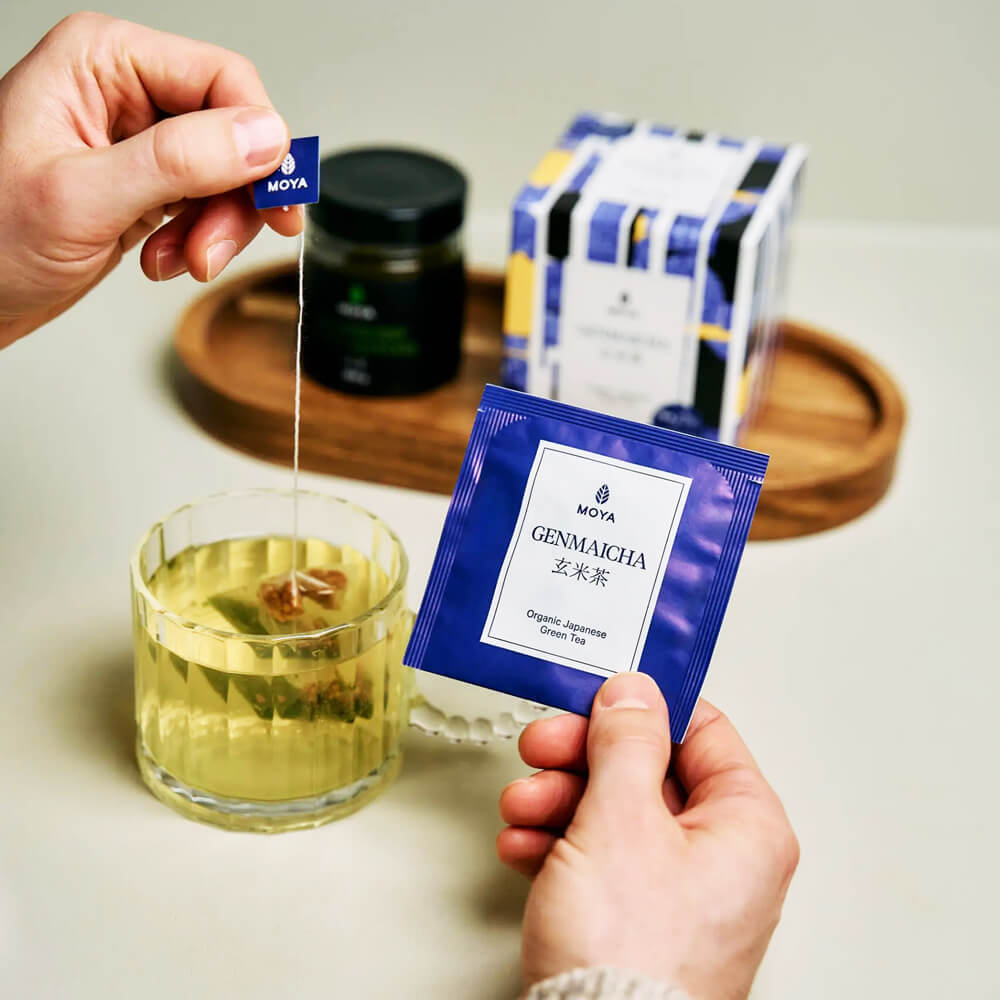 Genmaicha organikus japán filteres zöld tea filtertasak és doboz használat közben, csészével és kézzel