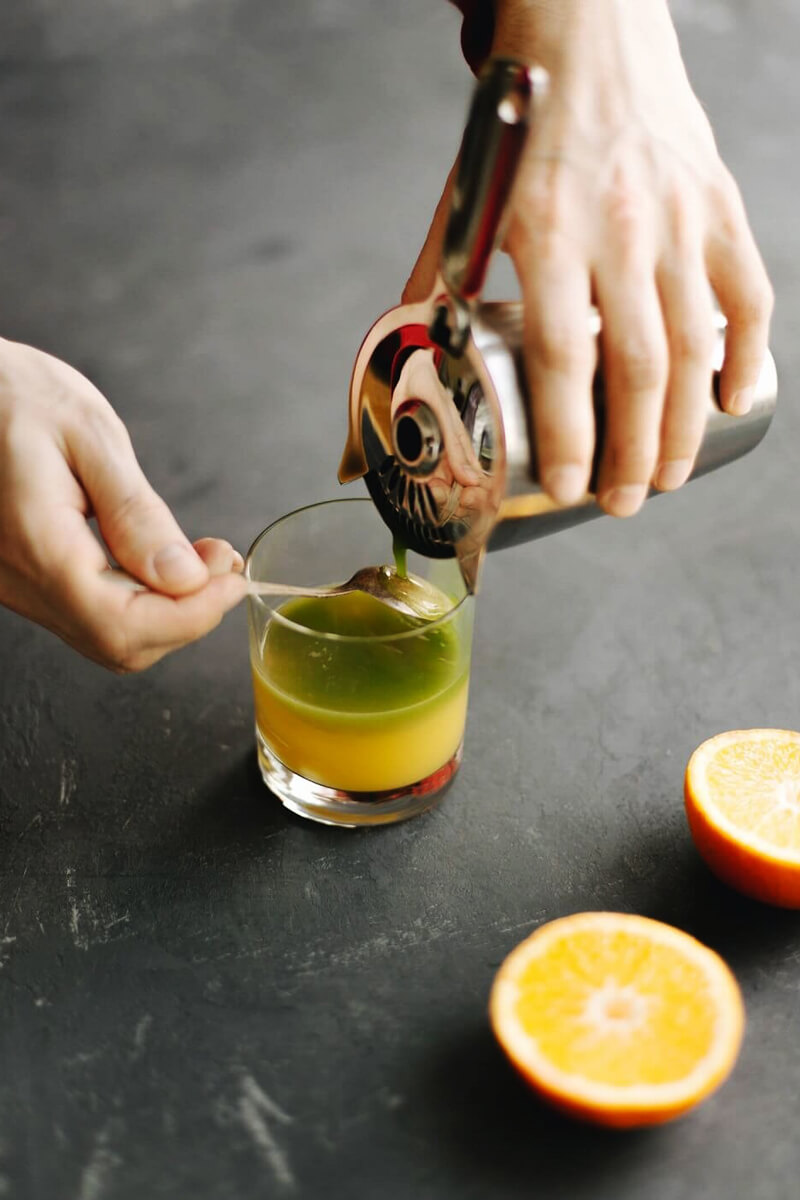 Matcha lassú ráöntése a narancsos rétegre kanál hátán, hogy megmaradjon a két réteg