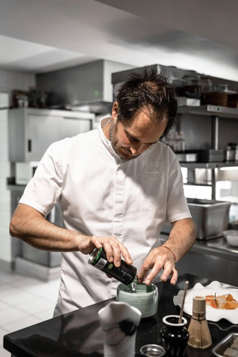 Séf matchát adagol a konyhában, előkészítés a matcha desszerthez