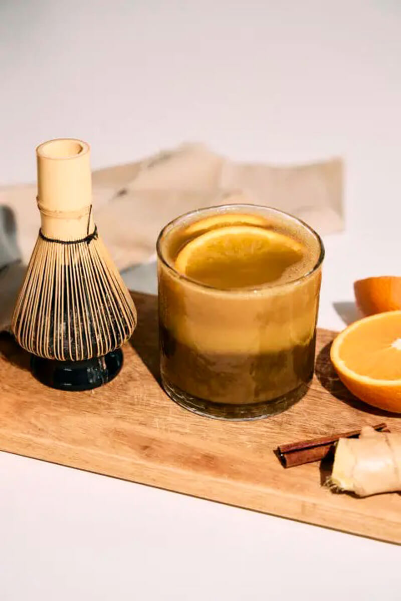 Gőzölgő hojicha narancsos fűszer ital narancsszelettel és téli fűszerekkel