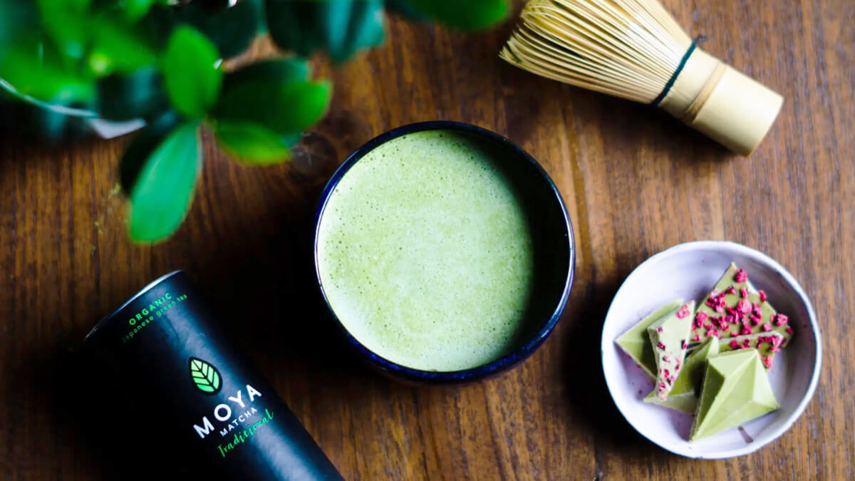 Minőségi matcha por választási tippekhez habos matcha tea látható chasennel, MOYA Matcha Traditional csomagolással.