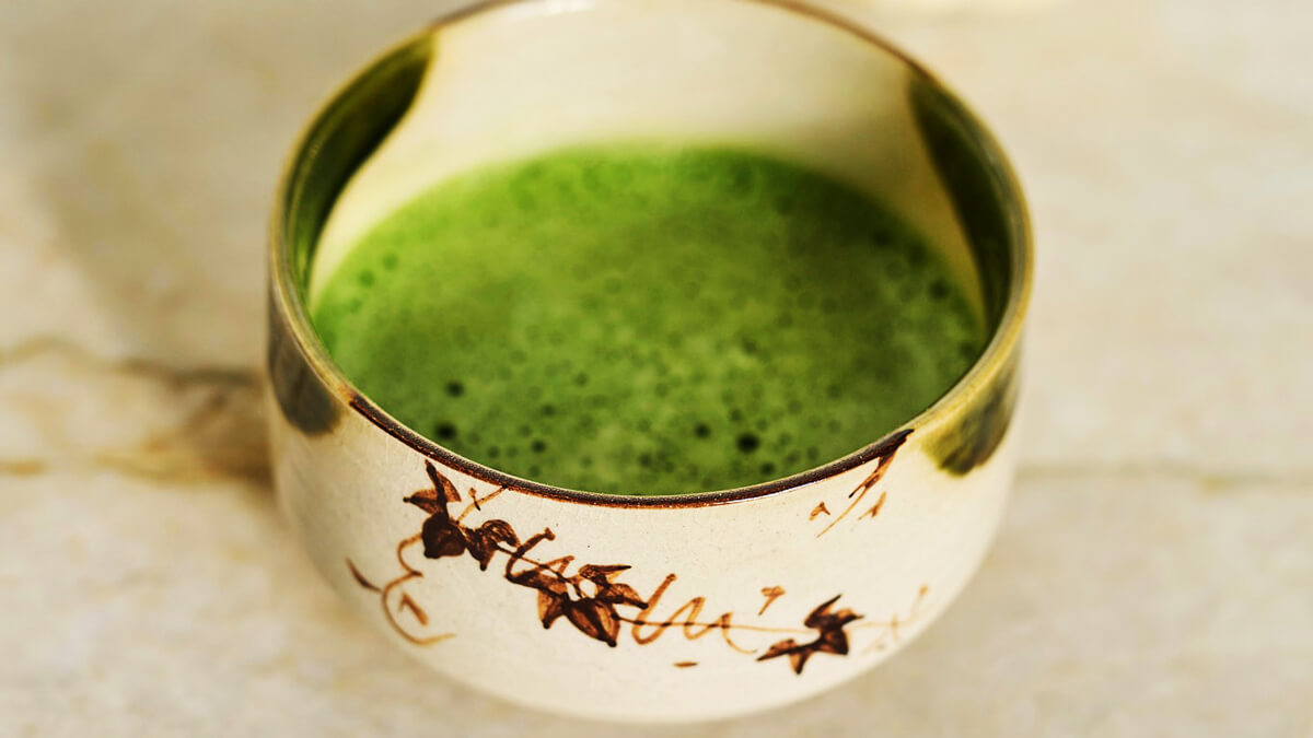 Habos matcha zöld tea kerámia csészében, felülről fotózva