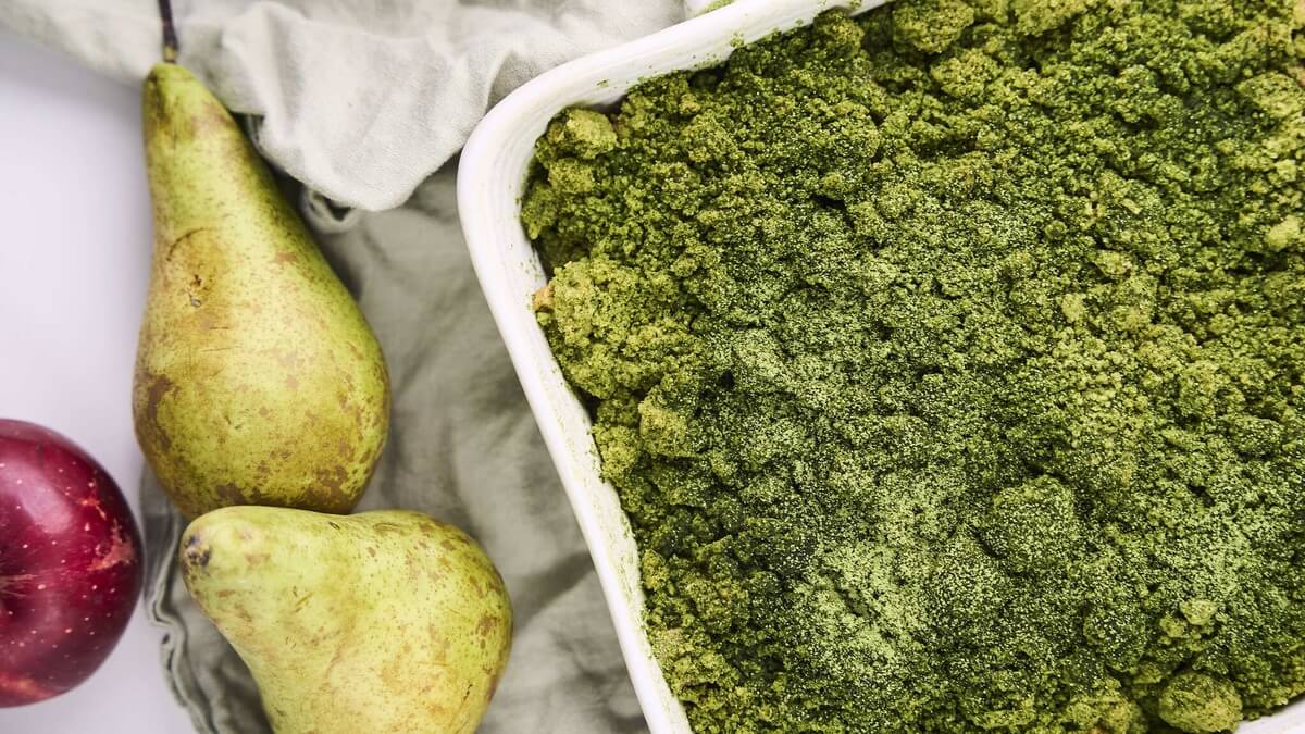 Matcha crumble almával és körtével Matcha crumble zöld morzsával a sütőformában, mellette friss körte és alma