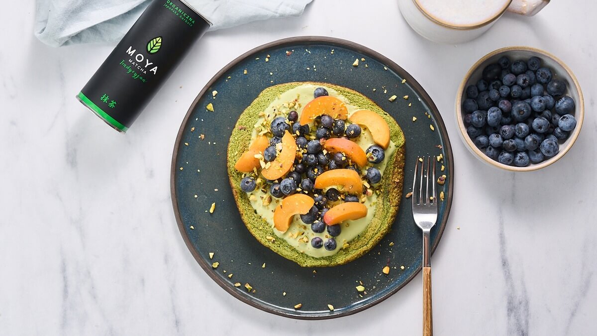 Matcha omlett tálalva Zöld matcha omlett kajszival, áfonyával és pisztáciával, mellette Moya matcha doboz