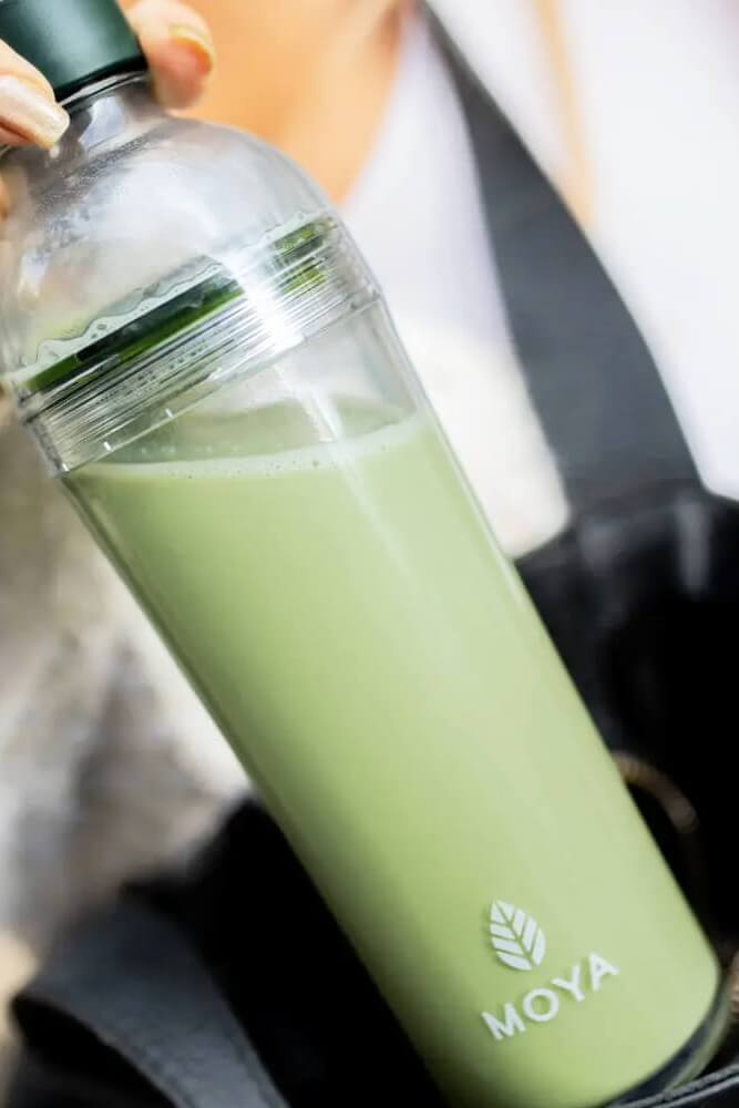 Fiatal nő matcha italt tart a kezében világos, nyugodt környezetben